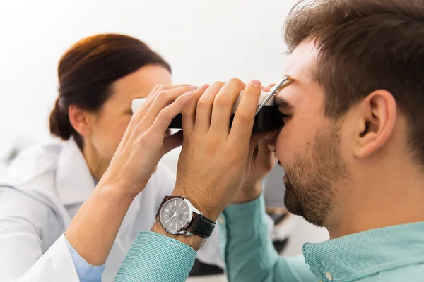 Gözlükçü pupillometer ve klinikte hasta ile — Stok fotoğraf