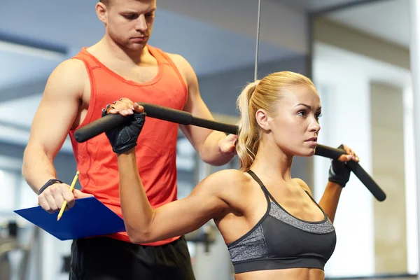 Hombres y mujeres flexionando los músculos en la máquina de gimnasio —  Fotos de Stock