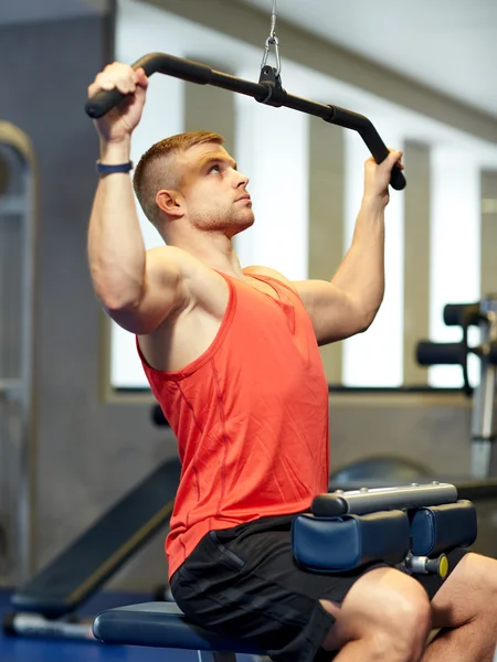 Man flexing muscles on cable machine gym — Stock Photo, Image