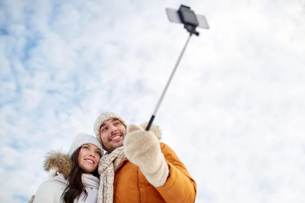 Feliz pareja tomando selfie por teléfono inteligente en invierno —  Fotos de Stock