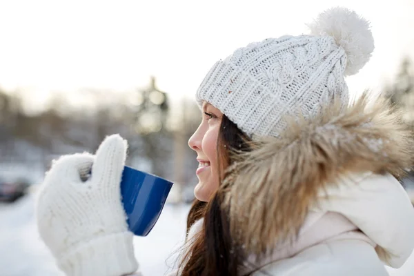 Jovem feliz com xícara de chá ao ar livre no inverno — Fotografia de Stock