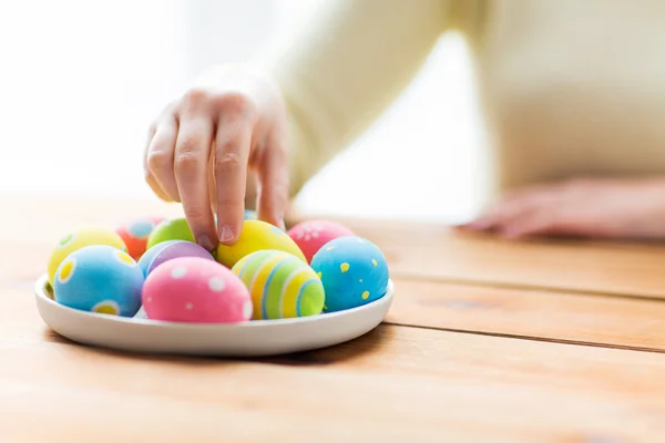 Gros plan des mains de la femme avec des œufs de Pâques colorés — Photo