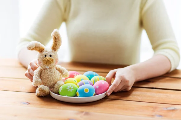 Close up of woman hands with easter eggs and bunny — Stock Photo, Image