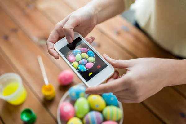 Primer plano de las manos con huevos de Pascua y smartphone —  Fotos de Stock