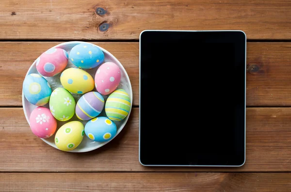Close up of easter eggs and blank tablet pc — Stock Photo, Image