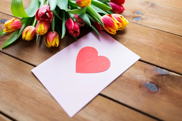 Primo piano di fiori e biglietto di auguri con cuore — Foto Stock