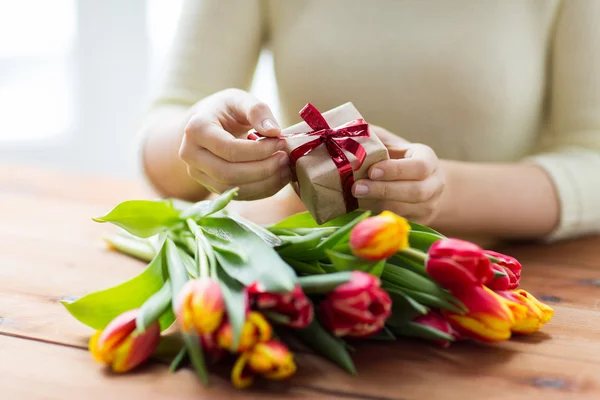 Nahaufnahme einer Frau mit Geschenkbox und Tulpenblumen — Stockfoto