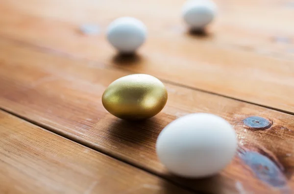 Primo piano di uova pasquali d'oro e bianche su legno — Foto Stock