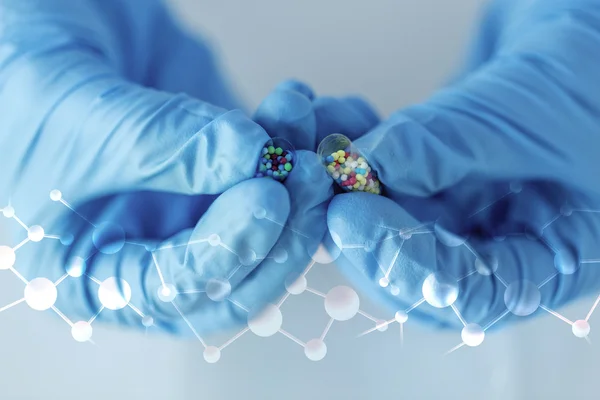 Gros plan des mains du scientifique tenant la pilule en laboratoire — Photo