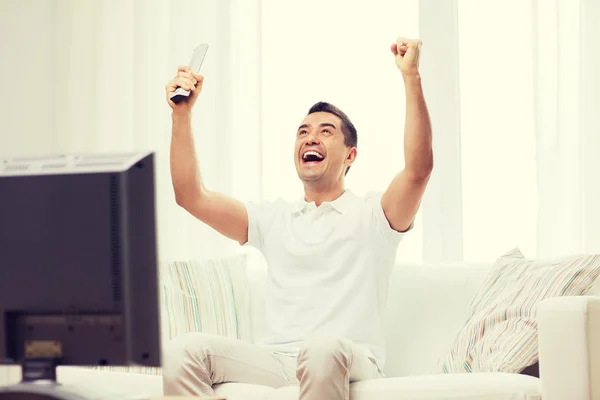 Sonriente hombre viendo deportes en casa —  Fotos de Stock