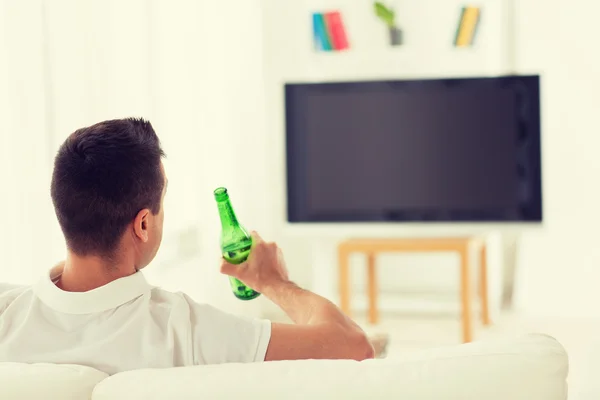 Man watching tv and drinking beer at home — Stock Photo, Image