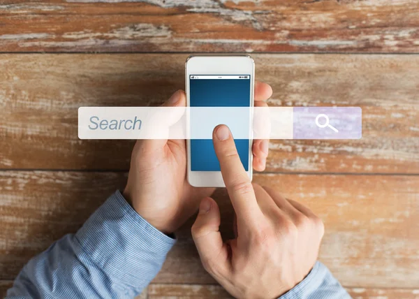 Close up of male hands with smartphone on table — Stock Photo, Image