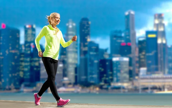 Gelukkige vrouw joggen over stad straat achtergrond — Stockfoto