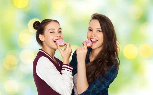 Happy pretty teenage girls eating donuts — Stock Photo, Image