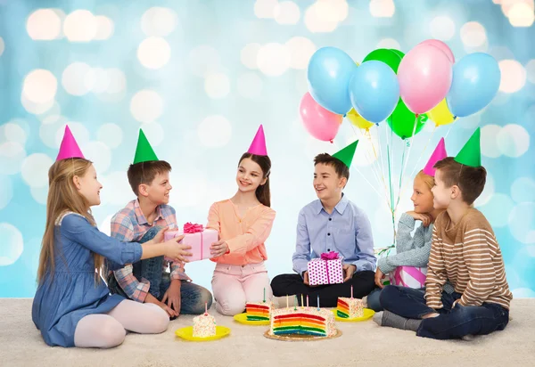De gelukkige kinderen geven geschenken op verjaardagsfeestje — Stockfoto