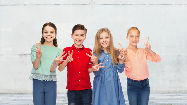 Niño feliz y las niñas mostrando la paz signo de mano —  Fotos de Stock