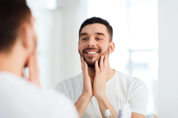 Feliz joven mirando al espejo en el baño en casa —  Fotos de Stock