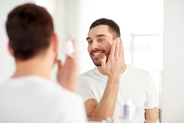 Homme heureux appliquant mousse à raser au miroir de salle de bain — Photo