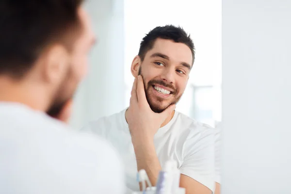 Jovem feliz olhando para o espelho, em casa, casa de banho — Fotografia de Stock