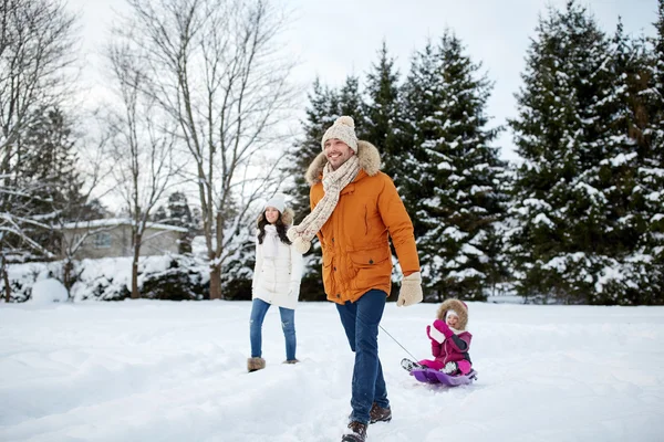 Šťastná rodina s saně v zimě venku — Stock fotografie
