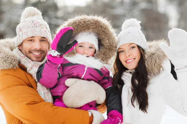 Familia feliz agitando las manos al aire libre en invierno —  Fotos de Stock