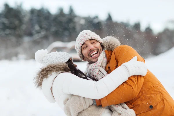 Gelukkige paar knuffelen en lachen in de winter — Stockfoto