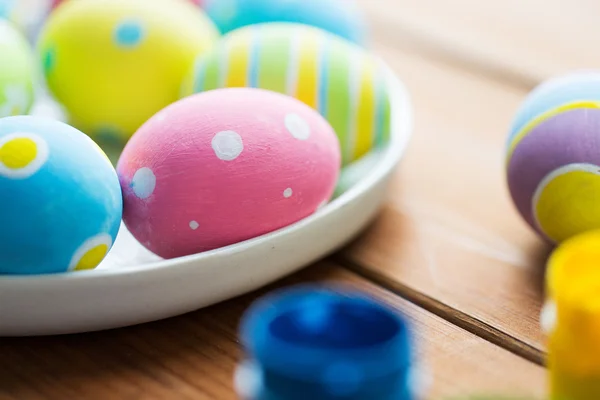 Закрытие цветных пасхальных яиц на тарелке — стоковое фото