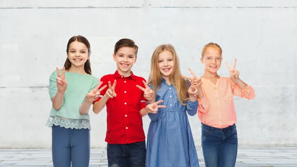 Menino feliz e meninas mostrando sinal de mão paz Fotografia De Stock