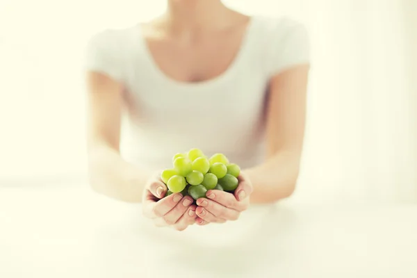 Primer plano de las manos de la mujer sosteniendo racimo de uva verde — Foto de Stock