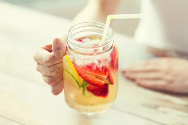 Närbild på kvinna med glas med frukt bevattnar — Stockfoto
