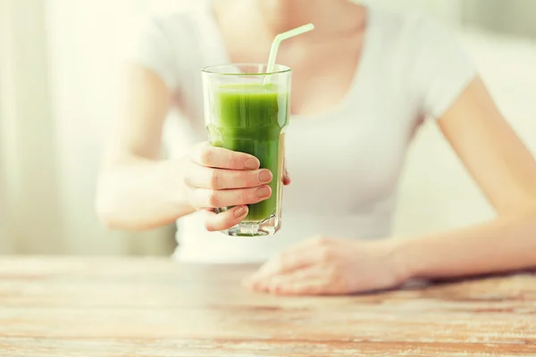 Close up de mãos de mulher com suco verde — Fotografia de Stock