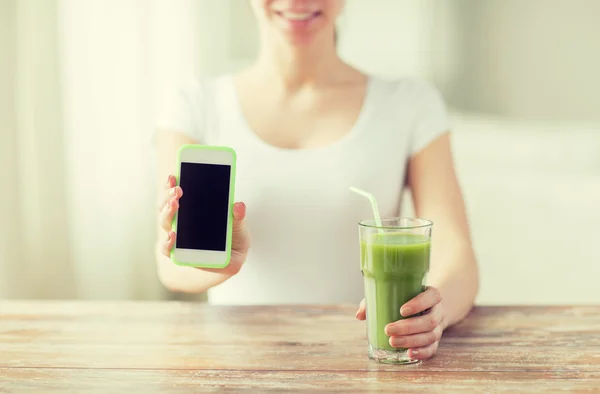 Close up of woman with smartphone and green juice — Stock Photo, Image