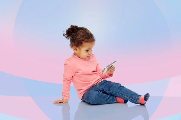 Uśmiechnięte dziecko dziewczynka gra z smartphone — Zdjęcie stockowe