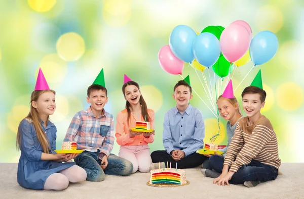 快乐的孩子们，在党的帽子与生日蛋糕 — 图库照片