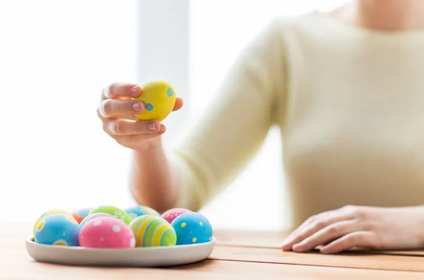 Закрыть руки женщины с цветными пасхальными яйцами — стоковое фото