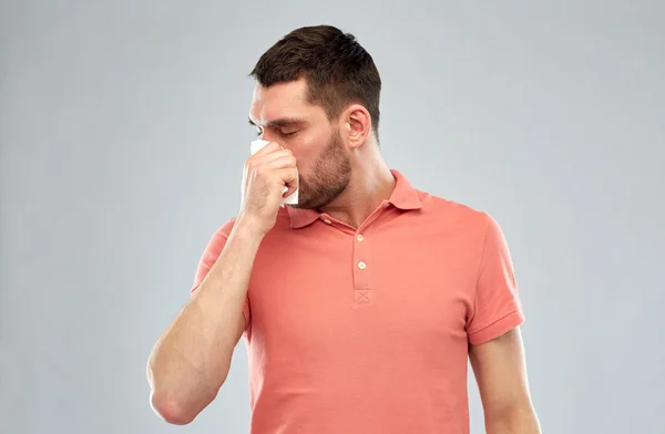 Больной человек с бумажной салфеткой сморщивает нос — стоковое фото