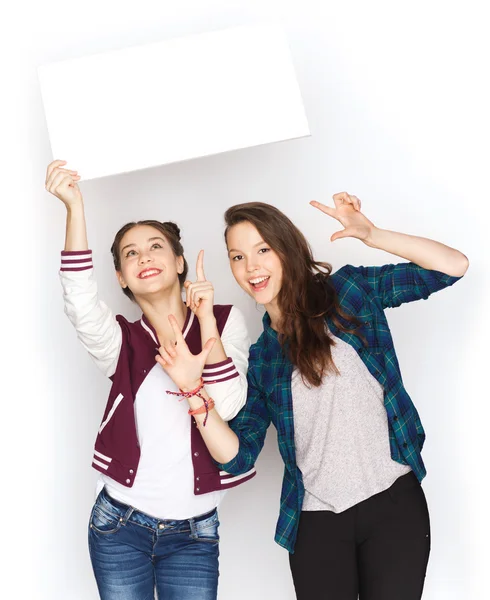 Smiling teenage girls holding white blank board — Stock Photo, Image