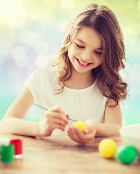Menina feliz com pincel colorir ovos de Páscoa — Fotografia de Stock