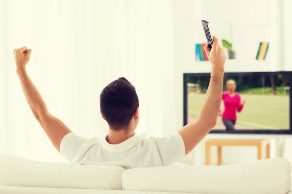 Hombre viendo canal deportivo en la televisión y en casa —  Fotos de Stock