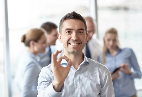 Grupo de empresarios sonrientes reunidos en el cargo — Foto de Stock