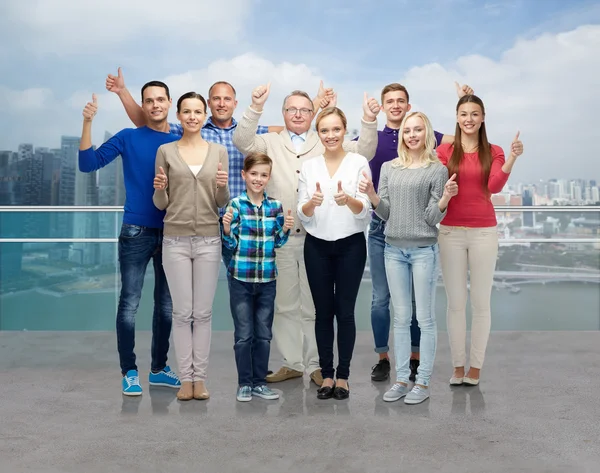 Grupo de personas sonrientes mostrando pulgares hacia arriba — Foto de Stock