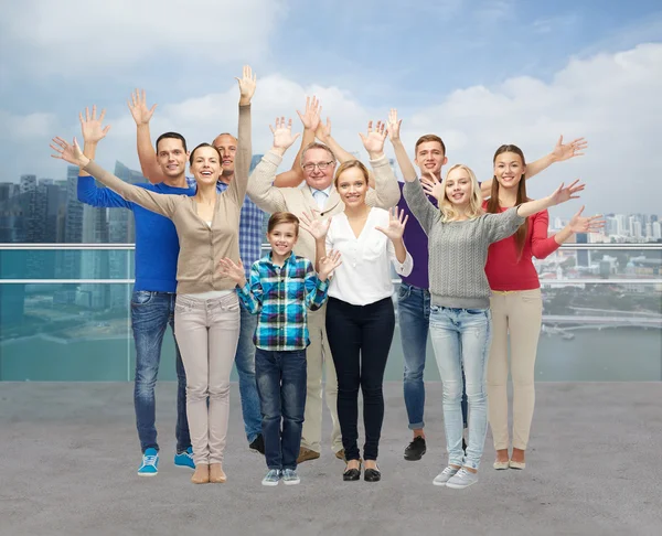 Grupo de personas sonrientes saludando con las manos — Foto de Stock