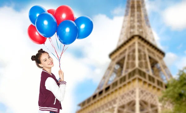 Teenage girl with balloons over eiffel tower — Zdjęcie stockowe