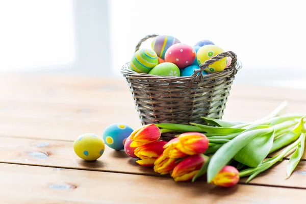 Zblízka na velikonoční vajíčka v košíku a květiny — Stock fotografie