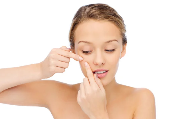 Young woman squeezing pimple on her face — Stock Photo, Image