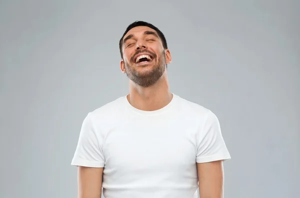 Lachender Mann vor grauem Hintergrund — Stockfoto