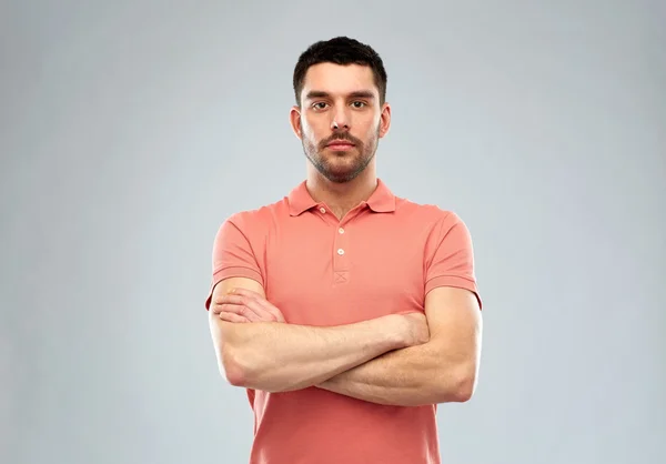 Young man with crossed arms over gray background — Stock Photo, Image