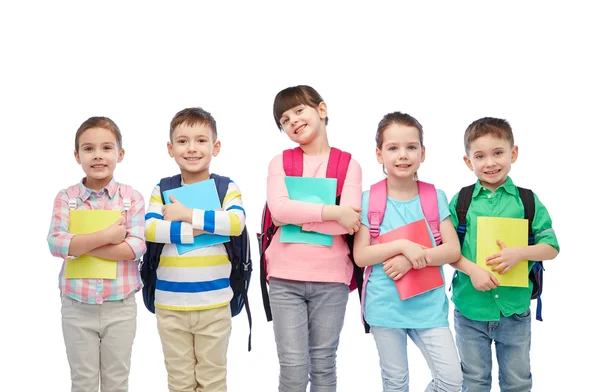 Crianças felizes com bolsas escolares e cadernos — Fotografia de Stock