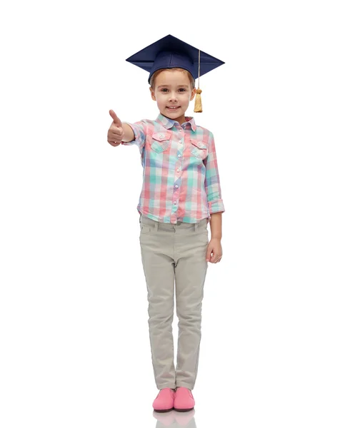 Happy girl in bachelor hat showing thumbs up — Stock Photo, Image