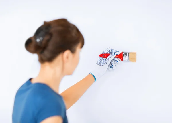 Frau mit Pinsel bemalt die Wand — Stockfoto